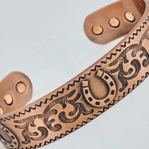 A close up of the copper bracelet with an image of a horse shoe.