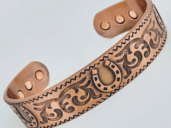 A close up of the copper bracelet with an image of a horse shoe.