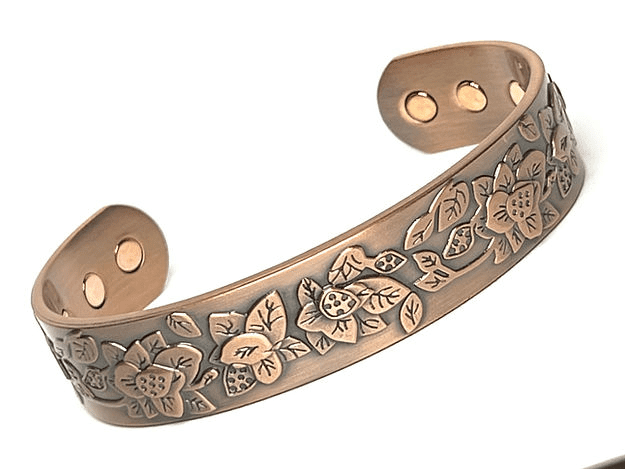 A copper bracelet with flowers and leaves on it.